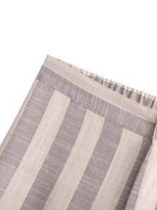 Détail de la texture d'un tissu à rayures beige et gris avec des coutures soignées