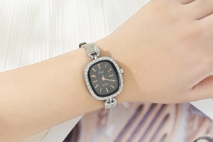 Elegant women's quartz watch with rhinestone bezel and silver mesh band on wrist
