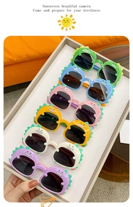 Close-up of colorful dinosaur-shaped kids sunglasses in green, blue and pink