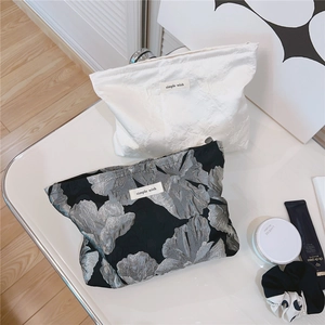Detail of jacquard makeup bag set with floral texture and elegant Simple Wish woven label