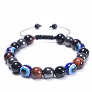 Dettaglio di perline occhio di tigre rosso da 10mm e ciondolo malocchio su bracciale intrecciato