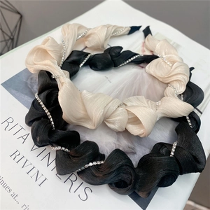 Close-up of pleated ruffle headbands with crystal rhinestone chain embellishments
