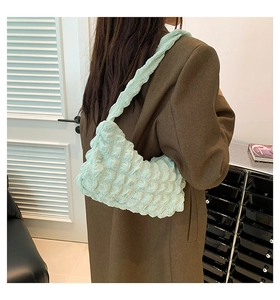 Detail of light mint green bubble textured fabric on a stylish shoulder underarm bag