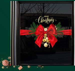 Detail of red Christmas bow with gold ornaments and stars for festive window decoration