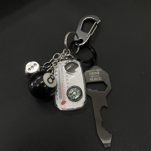 Detail of 8-ball keychain set featuring a bottle opener and mini functional tools