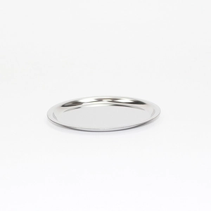 Close-up of a polished round stainless steel tea infuser tray on a white background