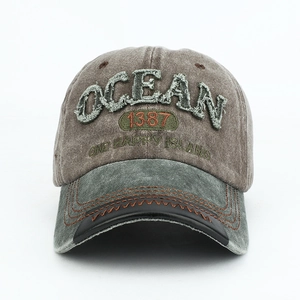 Detail of OCEAN patch embroidery and wave stitching on a vintage distressed dad hat
