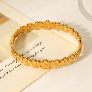 Close-up of 18K gold-plated stainless steel flower cuff bracelet with a warm gift card