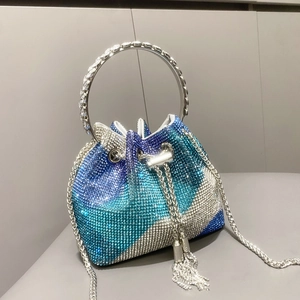 Dettaglio borsa a secchiello di lusso con strass blu e verdi sfumati e manico in cristallo
