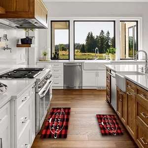 Detail view of red and black buffalo plaid Christmas kitchen mats on wooden floor