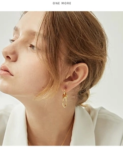 Detailed view of layered 18K gold-plated knotted earrings worn by a model