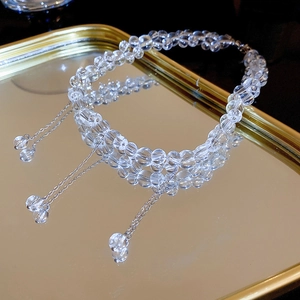 Macro shot of clear faceted crystal bead necklace on mirror tray with silver extension chain