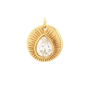 Detail of round gold pendant with teardrop zircon and sunburst engraved texture