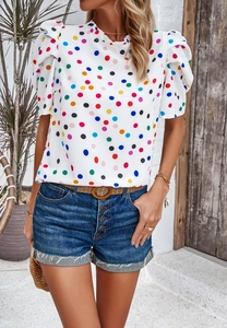 Nahaufnahme der Kurzarmbluse mit bunten Punkten und Puffärmeln sowie Denim-Shorts