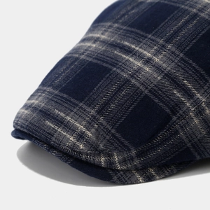 Macro view of navy blue plaid fabric texture and stitching on retro painter hat