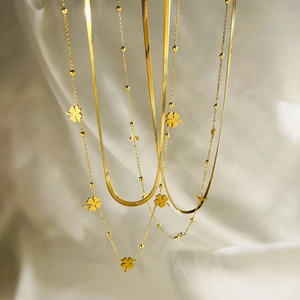 Gold layered stainless steel necklace with clover charms and flat snake chain