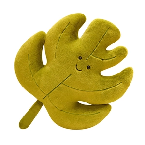 Cute monstera leaf plush pillow with embroidered smile and leaf veins on white background