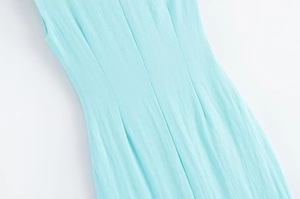 Détail du tissu en lin bleu clair et des coutures à la taille de la robe midi