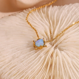 Detailed macro view of a teardrop opal pendant with gold plating and white zircon accents