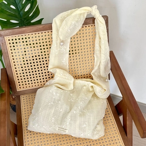 Detailaufnahme der Blumenstickerei auf Chiffon-Tasche mit Perlenanhänger und Logo
