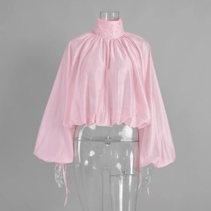 Close-up of pink satin high-neck blouse with lantern sleeves and textured folds