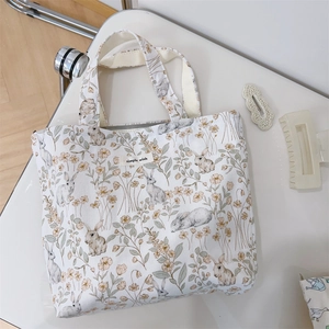 Close-up of cream canvas tote bag with bunny floral print and simple wish label