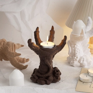 Detailed view of dragon claw candle holders with skulls and tea light candles in warm lighting
