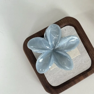 Blue and white marble plumeria hair claw clip made of elegant acetate material