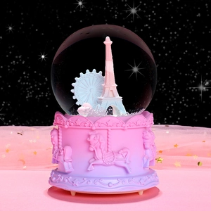 Pink carousel music box with Eiffel Tower snow globe showing detailed base relief