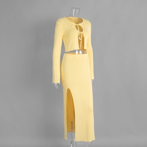 Detail of yellow ribbed knit set featuring tie-front cardigan and side-slit maxi skirt