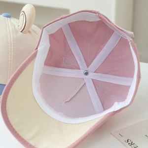 Close-up of pink and beige kids baseball cap showing breathable mesh lining and reinforced seams