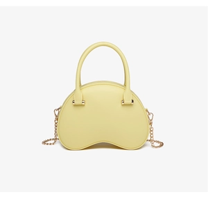 Close-up of a pale yellow jelly handbag with cloud-like texture and gold chain strap