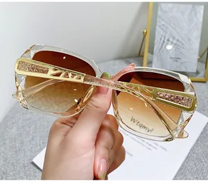 Detail of oversized sunglasses showing brown gradient lenses and gold hollow metal temples