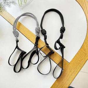 Detail of adjustable woven nylon shoulder straps in black and checkered patterns