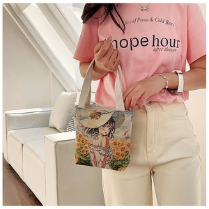 Detailed view of an ethnic style canvas tote bag featuring floral girl embroidery