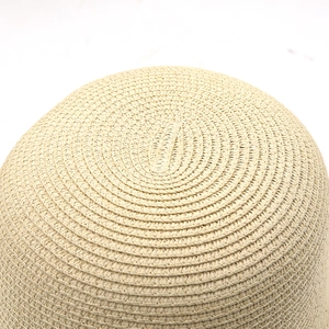 Détail d'un chapeau de paille tissé main montrant la texture en spirale et la matière