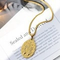 Detailed view of an oval gold coin pendant necklace resting on open book pages