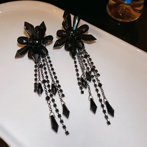 Gothic style black crystal flower tassel earrings with silver needle on white ceramic tray