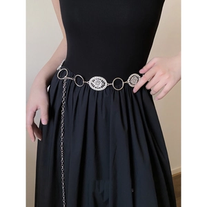 Detail of vintage silver metal waist chain belt with hollowed-out floral pattern