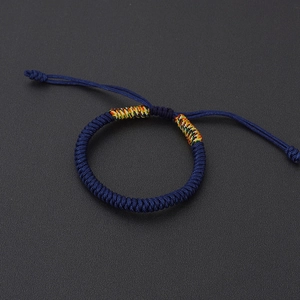 Macro detail of navy blue hand-woven rope bracelet with colorful decorative knots