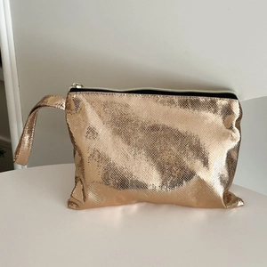 Golden snakeskin pattern makeup bag with metallic finish and wrist strap for women