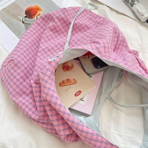 Spacious pink and purple plaid tote bag interior showing storage for books and a phone