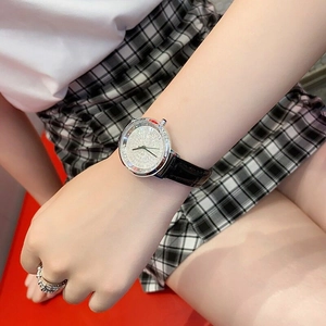 Elegant ladies' watch with silver case and black leather strap on a female wrist
