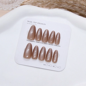 Press-on nails in translucent brown cat-eye effect with teardrop shape on white display