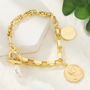 Detailed close-up of Baroque pearl bracelet with vintage gold coin charm and OT toggle clasp
