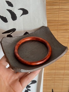 Détails de ce bracelet jonc en bois rouge poli aux textures naturelles élégantes
