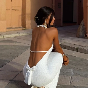 Detail of white backless dress featuring textured bubble fabric and bow tie closure