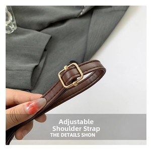 Detailed shot of an adjustable dark brown leather shoulder strap with golden metal buckle