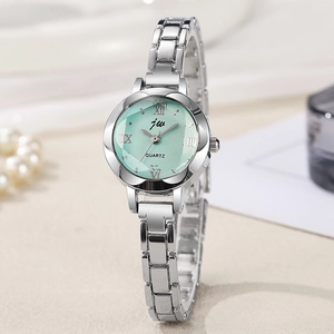 Close-up of small silver ladies watch featuring a green dial and elegant Roman numerals