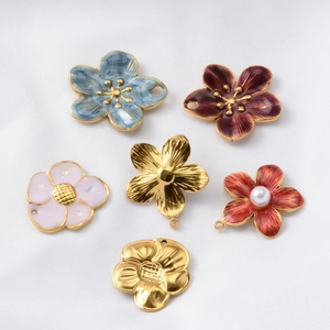 Detail view of colorful enamel flower charms and pearl petals for DIY jewelry making